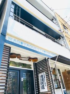 a building with a sign on the front of it at Otohaya Guesthouse in Nagoya