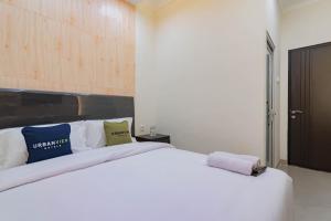 a white bed with two pillows on top of it at Urbanview Hotel Mamifokobo Puncak in Sindanglaya