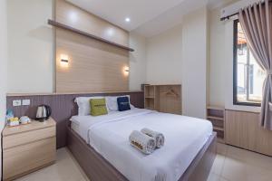 a bedroom with a large bed with two towels on it at Urbanview Hotel Mamifokobo Puncak in Sindanglaya