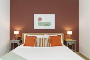 1 Schlafzimmer mit einem weißen Bett und 2 Tischen in der Unterkunft Maison Privee - Exquisite Apt on Yas Island cls to ALL attractions in Abu Dhabi