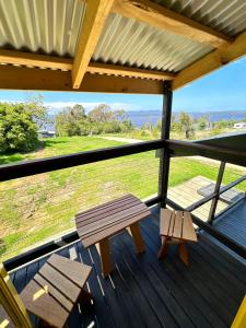a bench on a deck with a view of a field at Ocean Breeze Tiny House - Ocean and Lake View in Mallacoota
