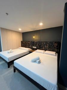 tres camas en una habitación con sábanas blancas en Maine City Residences Tramo, en Manila