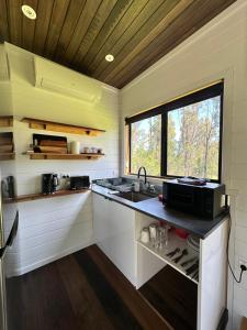 a small kitchen with a sink and a window at Ocean Breeze Tiny House - Ocean and Lake View in Mallacoota