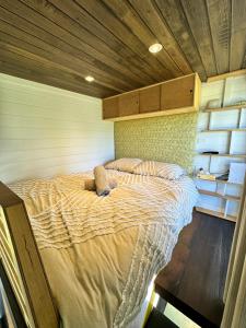 a bedroom with a large bed in a room at Ocean Breeze Tiny House - Ocean and Lake View in Mallacoota