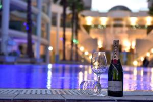 eine Flasche Wein und ein Glas neben einem Pool in der Unterkunft דירת גן על שפת הבריכה in Eilat