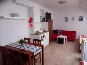 ミクロフにあるAlegria Natur Apartmentsの小さなリビングルーム(テーブル、赤いソファ付)