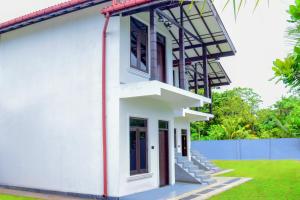 a white house with a staircase on the side at Muthu Villa 94 Midigama in Ahangama East