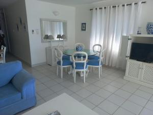 a living room with a table and chairs and a tv at 13 Bronze Bay in Durban