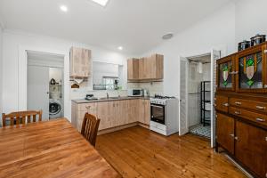 a kitchen with wooden cabinets and a wooden table in a room at Swainson on Church in Norwood