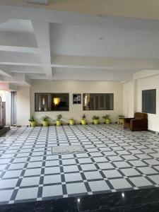 a lobby with a black and white checkered floor at Abuzz Oxfordcaps Cedar Homes in Jhājra