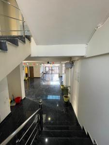 an empty hallway with stairs in a building at Abuzz Oxfordcaps Cedar Homes in Jhājra