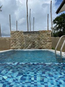 a large swimming pool with a stone wall at Lala Homestay 1 in Kuala Terengganu