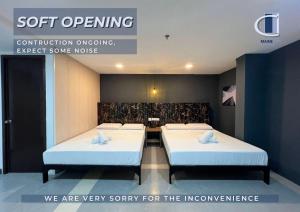 two beds in a room with a sign that says soft opening at Maine City Residences Tramo in Manila