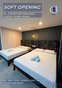 two beds in a room with a sign that says soft opening at Maine City Residences Tramo in Manila