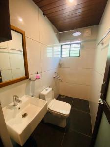ein Badezimmer mit einem weißen Waschbecken und einem WC in der Unterkunft Hotel Holiday Home in Kovalam