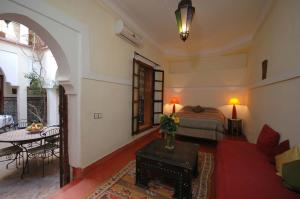 a living room with a bed and a table at Riad El Sagaya in Marrakech