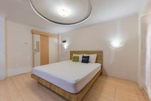 a bedroom with a large white bed in a room at Urbanview Hotel Anggrek Puncak by RedDoorz in Cianjur