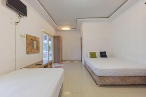 Katil atau katil-katil dalam bilik di Urbanview Hotel Anggrek Puncak by RedDoorz