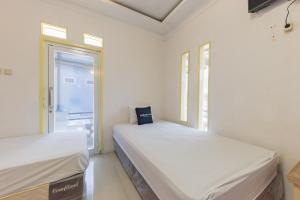 Katil atau katil-katil dalam bilik di Urbanview Hotel Anggrek Puncak by RedDoorz
