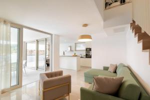Il comprend un salon avec un canapé vert et une cuisine. dans l'établissement Luxury & stylish Villa Lavanda 5 m from the sea, à Vela Luka