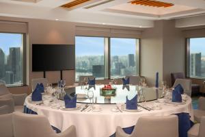 a conference room with a table and chairs and a screen at Novotel Atlantis Shanghai - Enjoy our great-valued breakfast in our rooftop revolving restaurant with a stunning river view & utilize our FREE self-serviced laundry in Shanghai