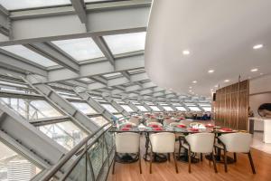a long room with a long table and chairs at Novotel Atlantis Shanghai - Enjoy our great-valued breakfast in our rooftop revolving restaurant with a stunning river view & utilize our FREE self-serviced laundry in Shanghai