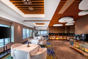 a restaurant with tables and chairs and a flat screen tv at Novotel Atlantis Shanghai - Enjoy our great-valued breakfast in our rooftop revolving restaurant with a stunning river view & utilize our FREE self-serviced laundry in Shanghai