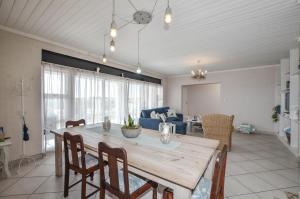 a dining room and living room with a table and chairs at 9 on Dolfyn in Yzerfontein