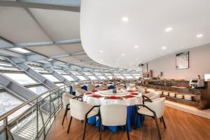a large room with a long table and chairs at Novotel Atlantis Shanghai - Enjoy our great-valued breakfast in our rooftop revolving restaurant with a stunning river view & utilize our FREE self-serviced laundry in Shanghai