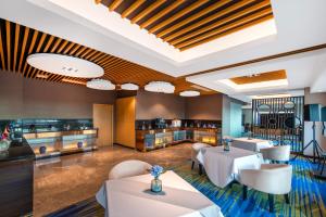 a restaurant with white tables and white chairs at Novotel Atlantis Shanghai - Enjoy our great-valued breakfast in our rooftop revolving restaurant with a stunning river view & utilize our FREE self-serviced laundry in Shanghai