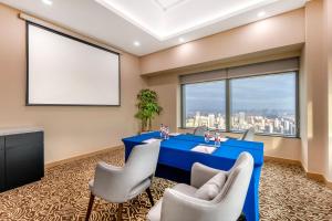 a meeting room with a blue table and chairs and a large window at Novotel Atlantis Shanghai - Enjoy our great-valued breakfast in our rooftop revolving restaurant with a stunning river view & utilize our FREE self-serviced laundry in Shanghai
