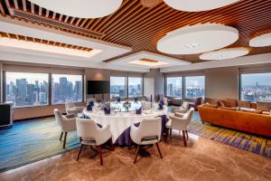 a conference room with a table and chairs and a couch at Novotel Atlantis Shanghai - Enjoy our great-valued breakfast in our rooftop revolving restaurant with a stunning river view & utilize our FREE self-serviced laundry in Shanghai