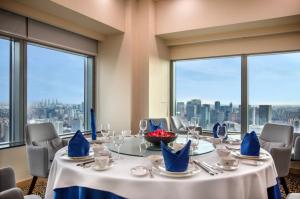 a dining room with a table with a view of the city at Novotel Atlantis Shanghai - Enjoy our great-valued breakfast in our rooftop revolving restaurant with a stunning river view & utilize our FREE self-serviced laundry in Shanghai