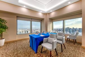 a conference room with a blue table and chairs and large windows at Novotel Atlantis Shanghai - Enjoy our great-valued breakfast in our rooftop revolving restaurant with a stunning river view & utilize our FREE self-serviced laundry in Shanghai