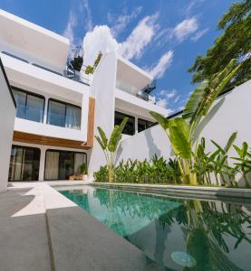an exterior view of a house with a swimming pool at Unity Villas Canggu in Canggu