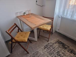 a table and two chairs in a room with a window at Apartament Ultracentral Suceava in Suceava