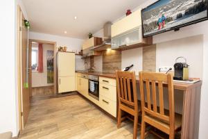 a kitchen with a table and chairs and a tv at Ferienwohnung Nagelschmied in Radstadt