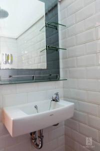 ein weißes Badezimmer mit Waschbecken und Spiegel in der Unterkunft Homestay Jogja Rumah Obit By Simply Homy in Timuran + 30 Fotos