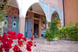 a building with red flowers in front of it at Riad SARSAR airport in Marrakesh +15 photos