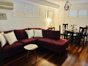 a living room with a red couch and a table at Swan Guest House in Brisbane