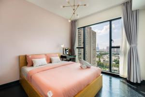 ein Schlafzimmer mit einem Bett und einem großen Fenster in der Unterkunft DingD0ng Home FelizEnVista 5-star facilities in Ho-Chi-Minh-Stadt