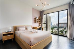 ein Schlafzimmer mit einem großen Bett und einem großen Fenster in der Unterkunft DingD0ng Home FelizEnVista 5-star facilities in Ho-Chi-Minh-Stadt