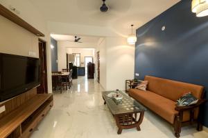 a living room with a couch and a tv at Plaza de Araujo in Benaulim