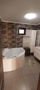 La salle de bains est pourvue d'une baignoire blanche et d'un lavabo. dans l'établissement Casa Catalin,Corbu, à Corbu