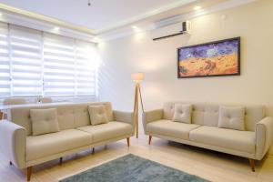 sala de estar con 2 sofás y TV en Flat w Balcony 5 min to Metro and Coast in Izmir en İzmir