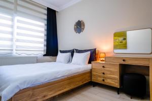 1 dormitorio con 1 cama y escritorio con TV en Flat w Balcony 5 min to Metro and Coast in Izmir en İzmir