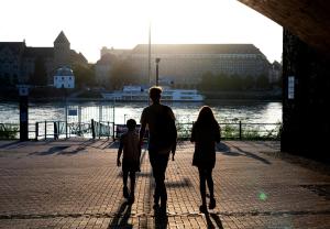 a man and a woman and child walking down a sidewalk at DIEHLs Guesthouse - Design-Apartments in Koblenz