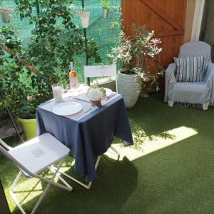 einen Tisch mit einem blauen Tischtuch und einem Stuhl in der Unterkunft Studio du Pouverel in La Garde