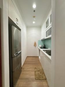  La cuisine est équipée de placards blancs et d'un réfrigérateur. dans l'établissement A delightful Vinhomes Times City apartment, à Hanoï