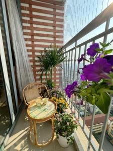 - un balcon avec une table et quelques fleurs dans l'établissement A delightful Vinhomes Times City apartment, à Hanoï